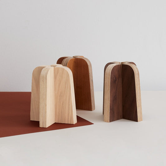 A set of three of Lozi's birch plywood candle holder, finished in oak, cherry and walnut veneer on a white background.