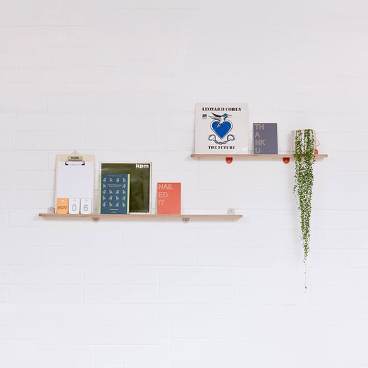 A pair of Lozi's plywood display shelves on a white brick background