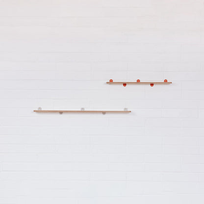 An empty pair of Lozi's plywood display shelves on a white brick background
