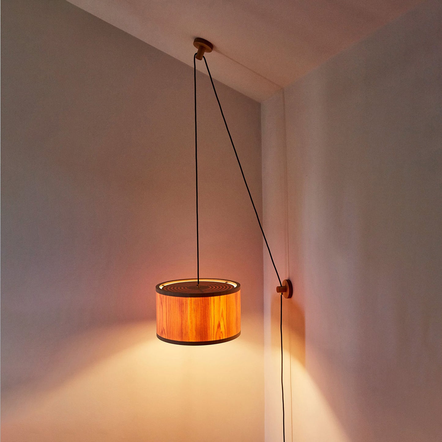 Lozi's plywood and translucent wood veneer Round Lamp wall and ceiling mounted, turned on in a dark room