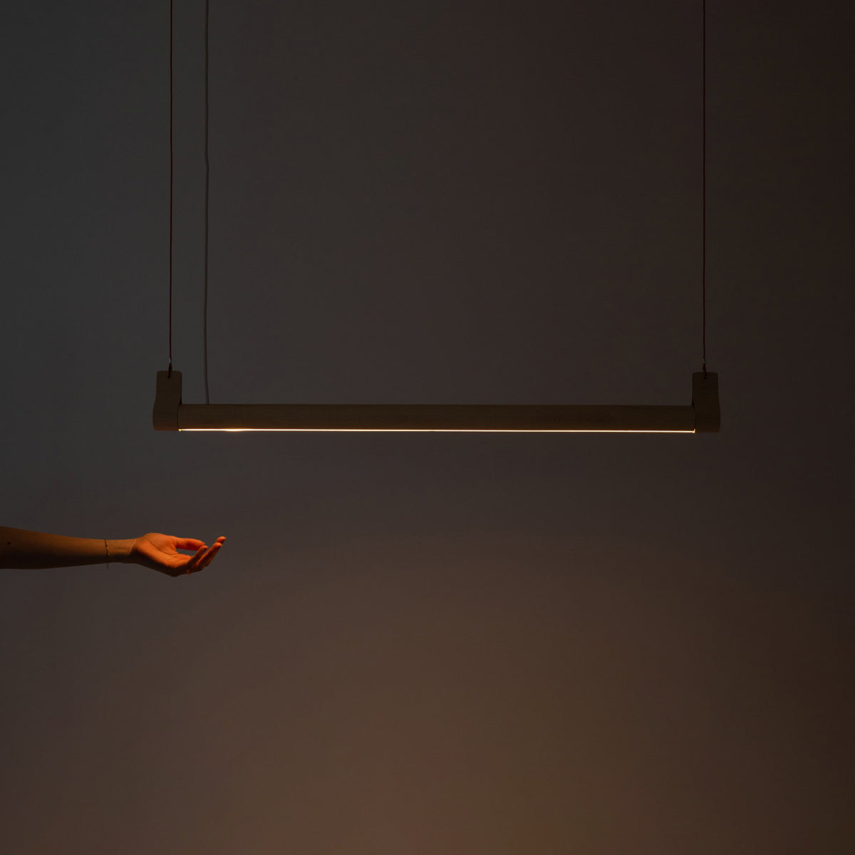 Lozi's wave beam light shown turned on in a dark room with light beaming downwards onto an outstretched hand