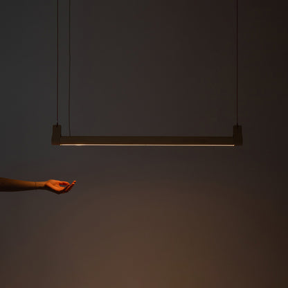 Lozi's wave beam light shown turned on in a dark room with light beaming downwards onto an outstretched hand